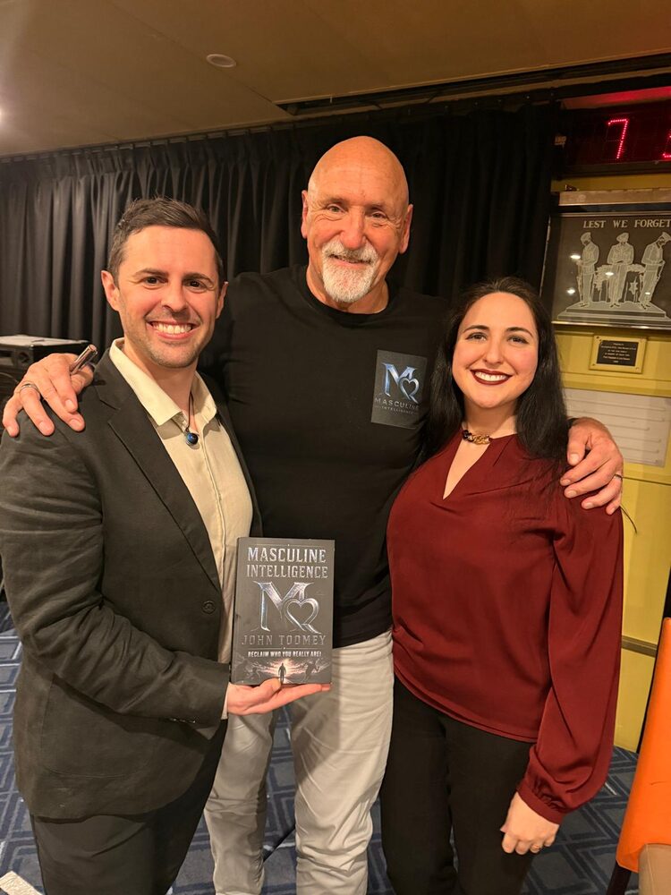 John Toomey with a guest holding copies of the book